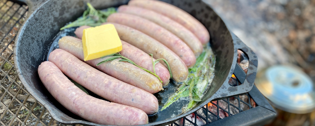 Sausages cooking in a cast iron skillet